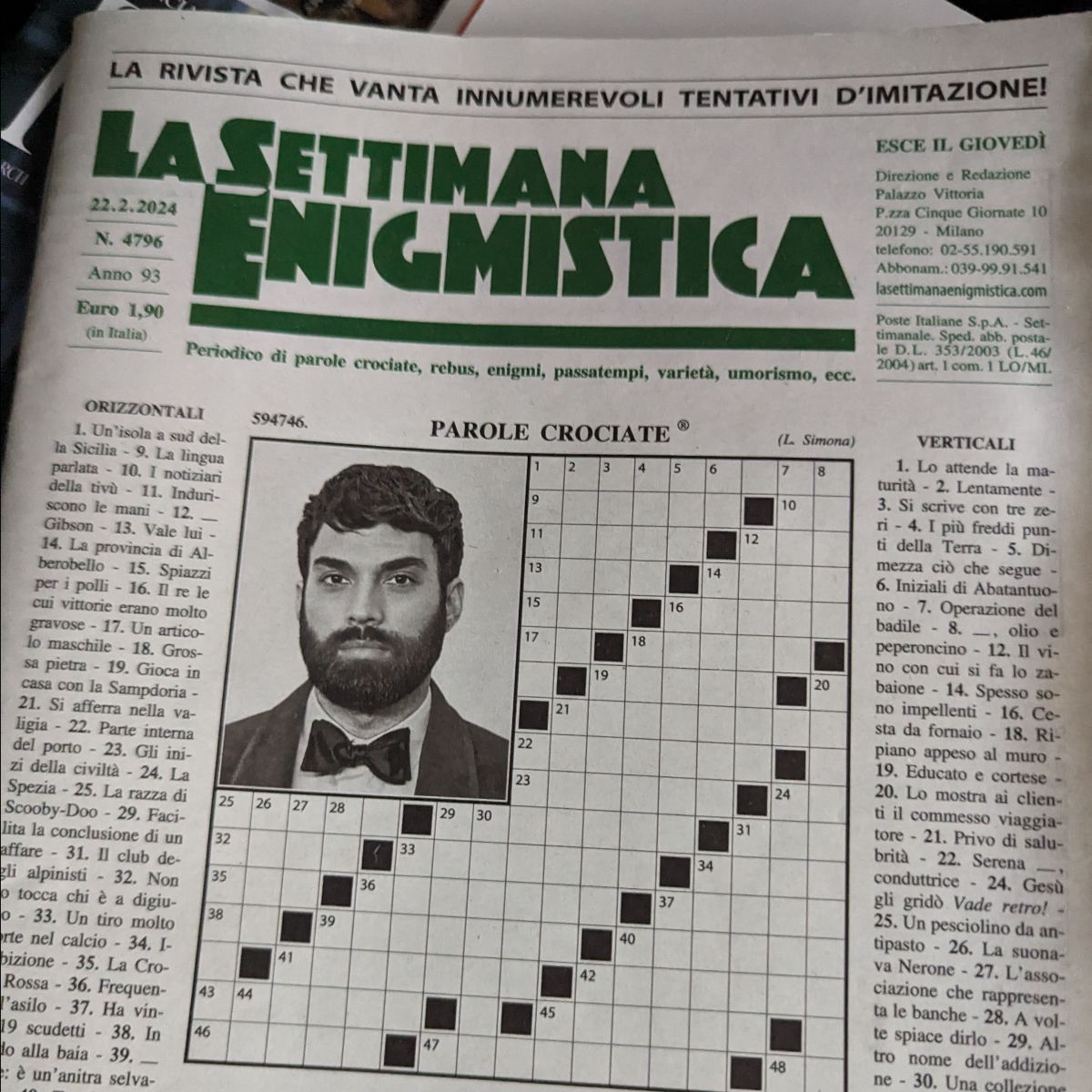 Image of an Italian newspaper, titled La Settimana Enigmistica', with columns, a crossword, and a man's portrait on the cover.